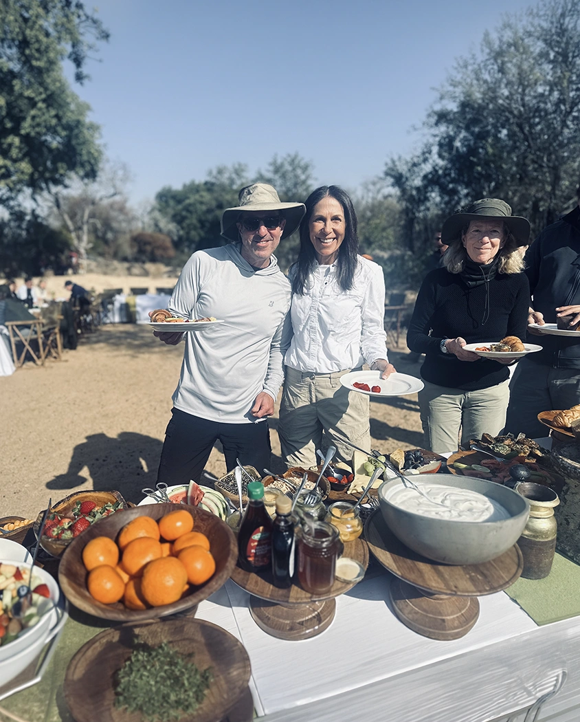 Hosts serving food to guests at an outdoor gathering
